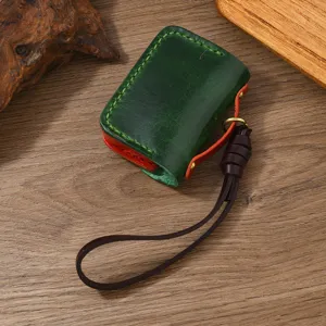 Dettaglio custodia AirPods vintage in pelle verde e rossa fatta a mano con cuciture