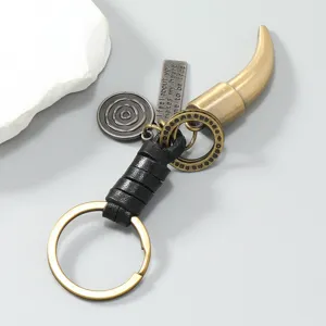 Macro d'un porte-clés dent de bête en bronze vintage avec cuir tressé détaillé