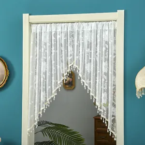 White lace door curtain detail, elegant floral pattern with beaded fringe for home decor.