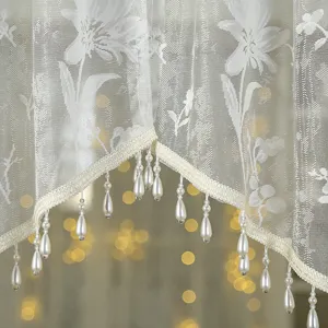 Detail shot of vintage french lace short curtain with floral embroidery and pearl bead fringe.