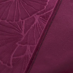 Detailansicht der dunkelpurpurnen Stoffabdeckung mit gepresstem Ginkgoblatt-Muster und Textur.