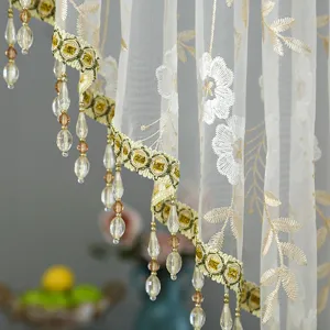 Exquisite lace curtain detail featuring floral embroidery, gold trim, and crystal bead tassels.