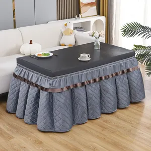 Rectangular quilted table cover for winter heating tables, thick plush fabric, elegant grey skirt.