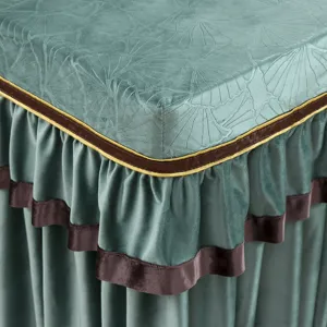 Nahaufnahme einer grünen geprägten Stofftischabdeckung mit elegantem Rüschenrand.