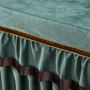 Nahaufnahme von grünem Samt Tischdecke Detail mit geprägtem Ginkgoblatt Muster und Borte.