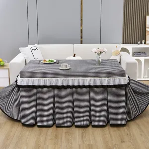 Detailed close-up view of the black and white plaid heating table cover with exquisite lace trim.