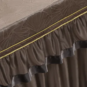 Braune Tischabdeckung mit Ginkgoblatt-Prägung, Goldrand und Rüschenrock für Dekoration.