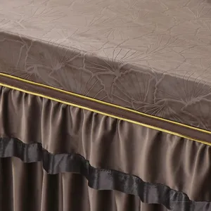 Nahaufnahme der braunen Stofftischdecke mit geprägtem Ginkgoblattmuster und Rüschenkanten.