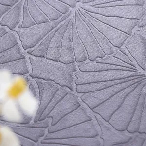 Nahaufnahme von lilafarbenem Stoff mit geprägtem Ginkgoblatt-Muster für Tischdecken.