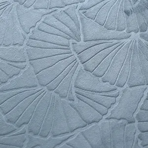Detailaufnahme einer graublauen Stofftischdecke mit elegantem geprägtem Ginkgoblatt-Muster.