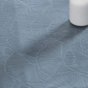 Nahaufnahme einer eleganten blauen Tischdecke aus Stoff mit strukturiertem Ginkgoblatt.
