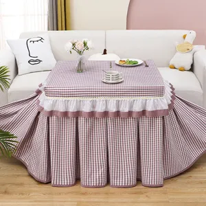 Plaid heating table cover detail showing velvet fabric texture, white lace trim and neat stitching.