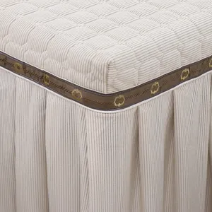 Beige gesteppte Tischabdeckung Detail mit elegantem braunen Zierstreifen und Plissee Rock.