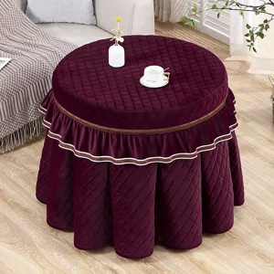 Verdikte fluwelen ronde tafelhoes met gewatteerd ontwerp en elegante volants in huis.
