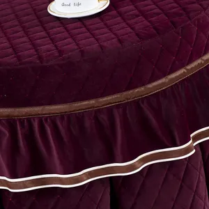 Verdikte fluwelen ronde tafelhoes met gewatteerd patroon en elegante geplooide rand detail.