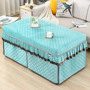 Quilted cyan heating table cover detail showing plush velvet texture and elegant ruffled skirt.