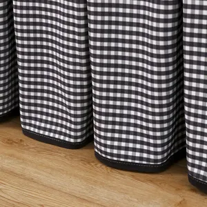 Black and white checkered table cover detail, soft fabric texture with neat pleated design for home.
