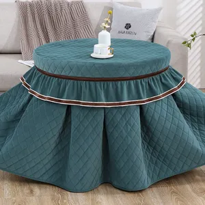 Verdikte gewatteerde ronde tafelhoes met elegante geplooide rok, gezellige huisdecoratie.
