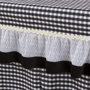 Black and white checkered table cover detail with floral lace trim and mesh ruffles.