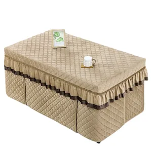 Quilted rectangular heating table cover with elegant brown ruffle trim for winter use.
