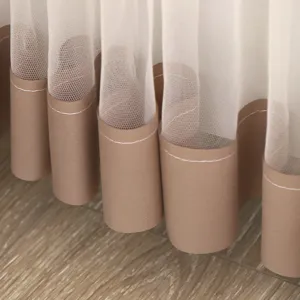 Detail view of the stylish white tulle curtain with brown fabric hem for home decor.