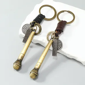 Detailopname van retro metalen microfoon sleutelhangers met leren koord en labels