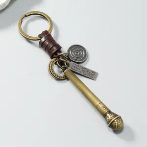 Detailopname van vintage bronzen microfoon sleutelhanger met lederen riem.