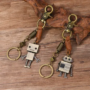 Detail of retro metal robot keychains with cowhide leather cords on wooden surface