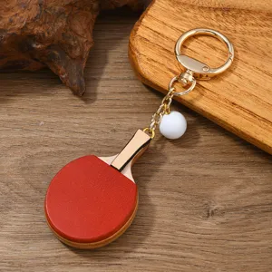 Nahaufnahme eines Retro-Minipis-Ping-Pong-Schläger-Schlüsselanhängers mit weißem Ball