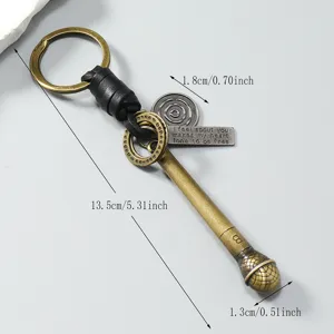 Vintage metalen microfoon sleutelhanger met leer en bedeltjes, afmetingen getoond.
