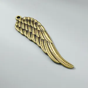 Detailed macro view of an antique bronze wing pendant with intricate feather textures