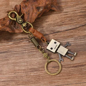 Close-up detail of a vintage robot keychain with bronze metal parts and brown leather