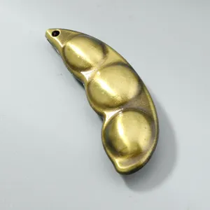 Detailed macro view of a vintage bronze peapod pendant charm for DIY jewelry crafting projects