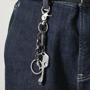 Detail van een vintage metalen multitool-sleutelhanger aan een spijkerbroek