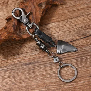 Macro view of vintage metal keychain detail with shark tooth pendant on rustic wood