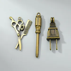 Primer plano de dijes de aleación de bronce antiguo retro que incluyen tijeras y destornillador.