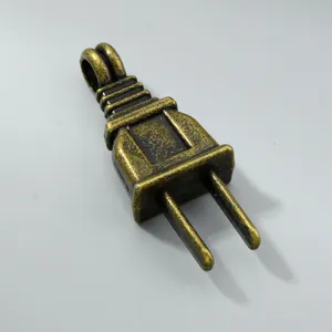 Detalle de un colgante vintage de aleación de bronce con forma de enchufe