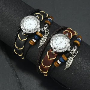 Detail of vintage bohemian leather wrap watches with feather pendants in black and brown.