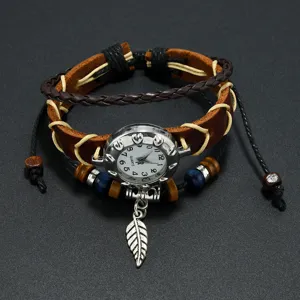 Detail view of a vintage bohemian leather bracelet watch with a silver feather pendant.