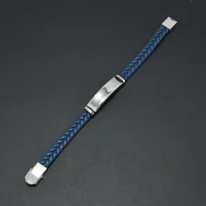 Macro view of blue braided leather bracelet with silver stainless steel ID plate.