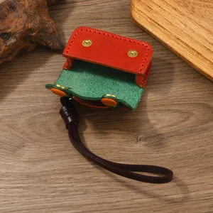 Vista dettagliata della custodia AirPods in pelle rossa e verde con bordi cuciti a mano