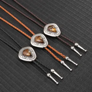 Detailansicht von geflochtenen Leder-Boloties mit silbernen Tigeraugen-Anhängern.