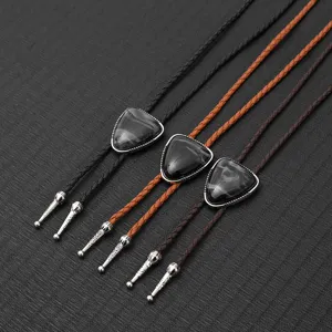 Three vintage bolo ties with braided PU leather cords and marble stone pendants on black fabric.