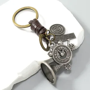 Close-up of vintage leather keychain with clock and engraved heart quote plate