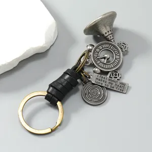 Detail view of a vintage metal horn keychain featuring black leather wrap and engraved quote tag