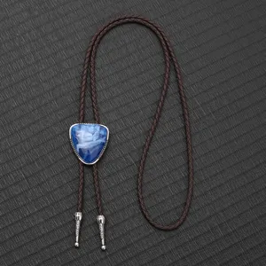 Vintage-Bolo-Krawatte mit blauem Stein und brauner Kordel auf strukturiertem Hintergrund.