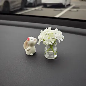 Nahaufnahme von süßem Kaninchen und Mini Blumenvase Auto Armaturenbrett Innendeko.