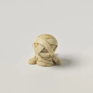 Close-up detail of the cute miniature mummy figurine, perfect for desk and car decoration.