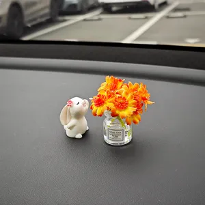 Detailaufnahme eines süßen Harz-Hasen und Mini-Blumenglas-Auto-Armaturenbremsschmucks.