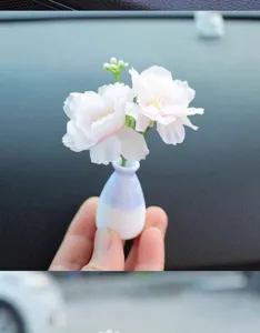 Mini car artificial flower vase detail showing cute micro landscape ornament for dashboard decor.